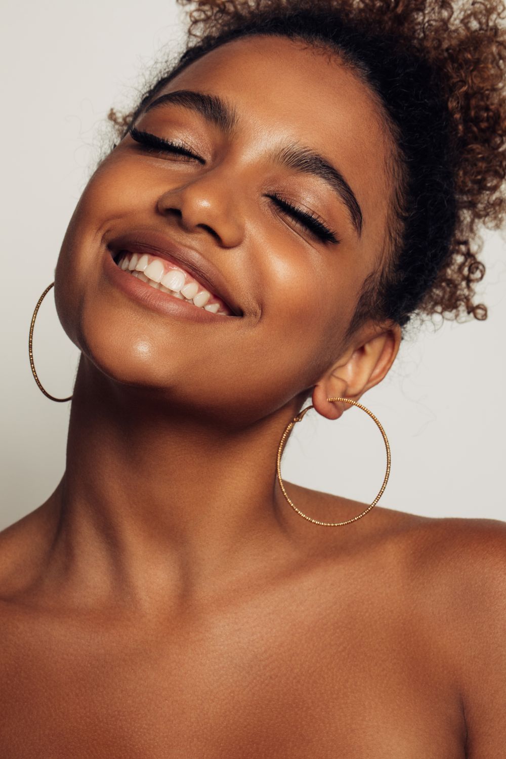 med spa patient model smiling with hoop earrings