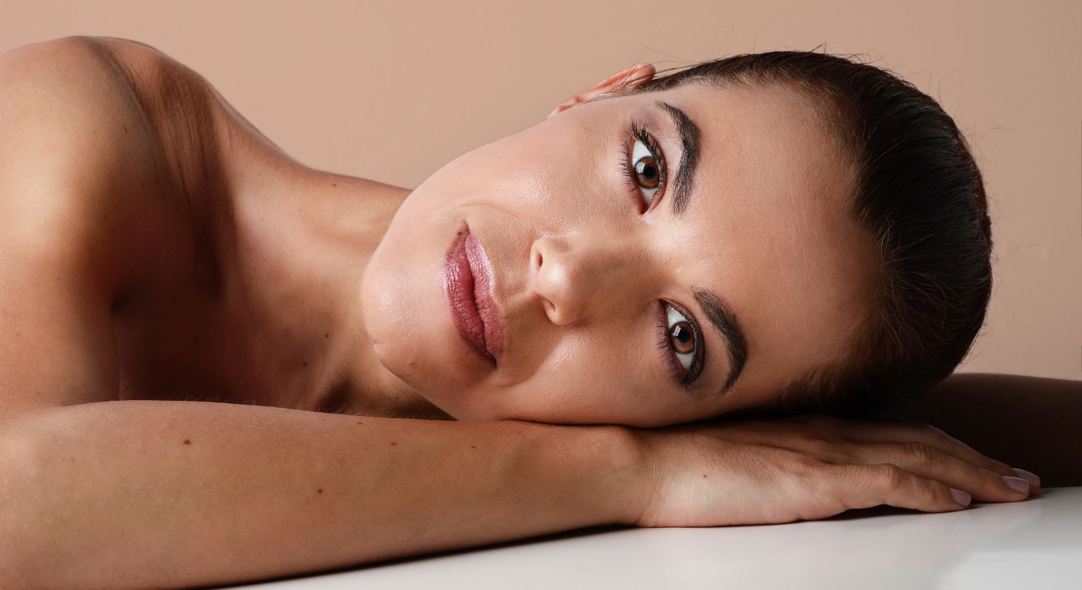 skin rejuvenation patient model laying down and resting her head on her hands