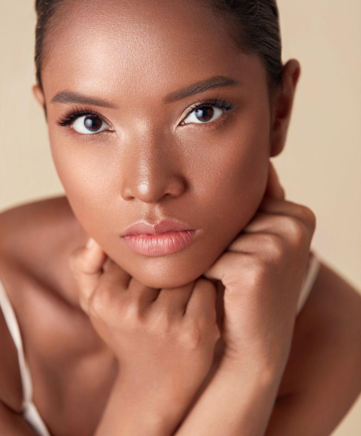 hydrafacial patient model resting her chin on her fists